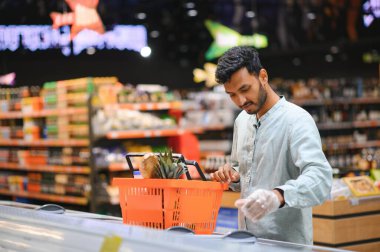 Markette ya da süpermarkette duran yakışıklı Hintli genç adamın portresi. Seçici Odaklanma