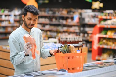 Markette ya da süpermarkette duran yakışıklı Hintli genç adamın portresi. Seçici Odaklanma