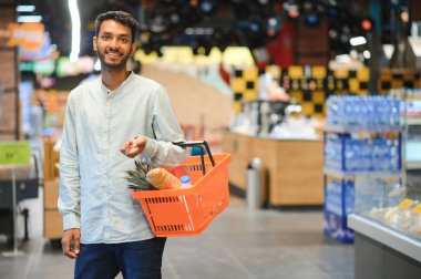 Markette ya da süpermarkette duran yakışıklı Hintli genç adamın portresi. Seçici Odaklanma