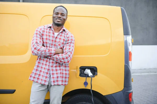 Seorang Pria Afrika Amerika Berdiri Samping Van Pengiriman Listrik Kuning — Stok Foto