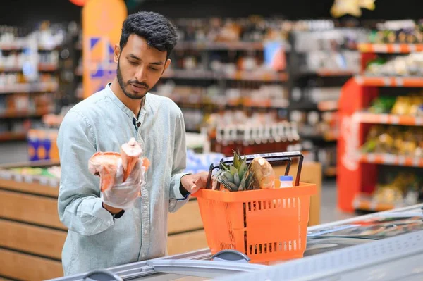 Portrait of indian man purchasing in a grocery store. Buying grocery for home in a supermarket.