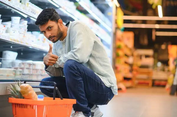 portrait of indian male in grocery with positive attitude.