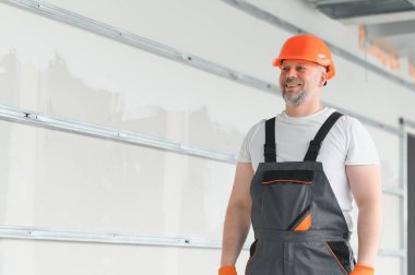 Olumlu, yakışıklı erkek müteahhit portresi. Tamirci geldi.