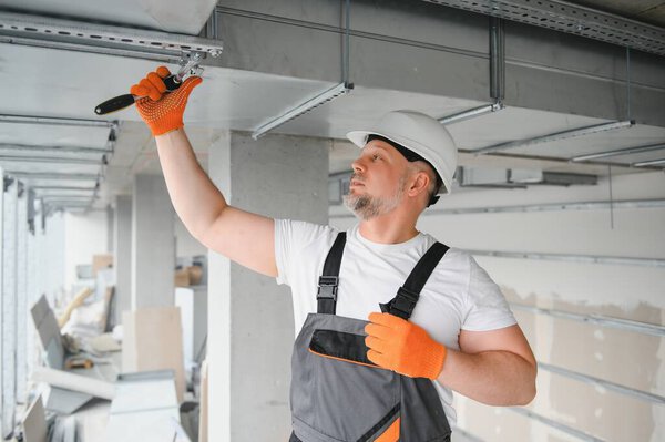 Man repairman. Master near ventilation pipes. Installation of ventilation for buildings. Man repairman with back to camera. Metal ventilation pipes