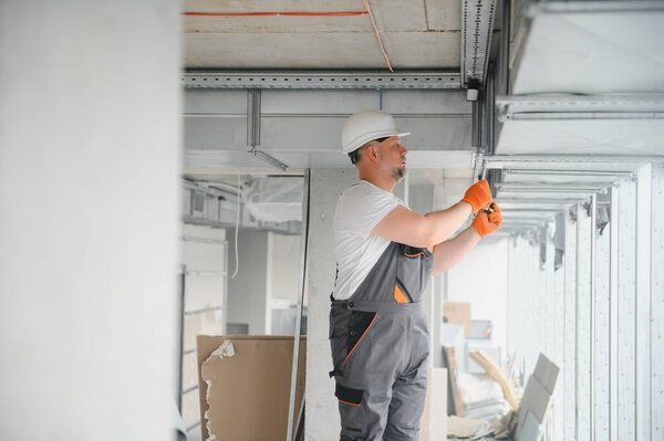 hvac services - worker install ducted pipe system for ventilation and air conditioning in office
