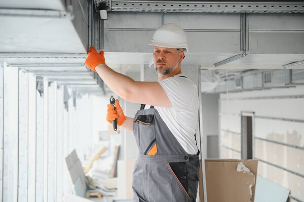 hvac services - worker install ducted pipe system for ventilation and air conditioning in office