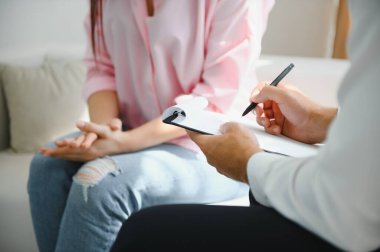 Akıl sağlığı sorunları olan bir kadın danışmanlık yapıyor. Psikiyatrist tedavi için hastanın durumunu kaydediyor. teşvik, sevgi ve aile sorunu, bipolar, depresyon hastası, intiharı koru