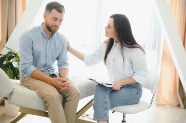 female psychologist making note while patient talking.