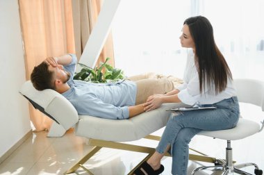 female psychologist making note while patient talking.