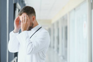 Üzgün doktor hastane koridorunda duran.