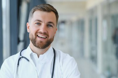 Genç bir erkek doktor genel bir hastanenin koridorunda..