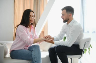 Psikolog, ofisinde üzgün genç bir bayanla terapi seansı sırasında notlar alıyor. Boşluğu kopyala.