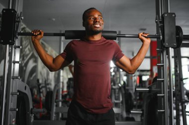 Afrikalı Amerikalı genç adam spor salonunda çalışıyor..