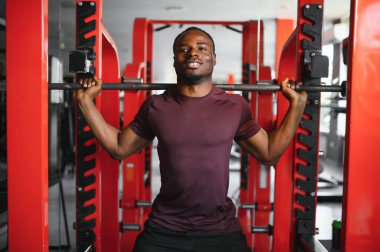 Afrikalı Amerikalı genç adam spor salonunda çalışıyor..