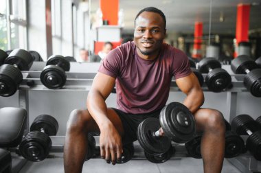 Afrikalı Amerikalı genç adam spor salonunda çalışıyor..