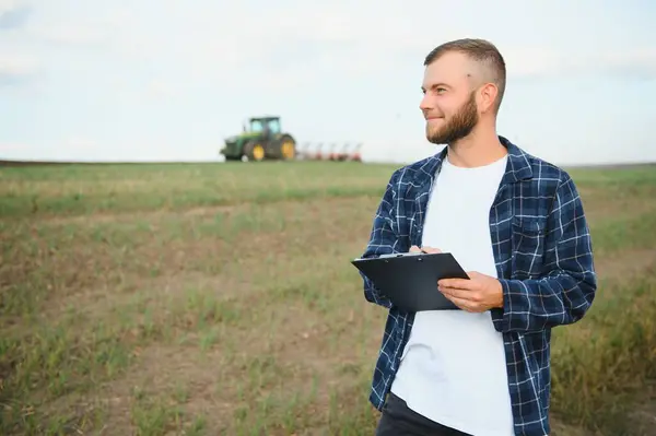 Framer Kontroluje Pracę Terenie Pomocą Tabletu Ciągnik Tle — Zdjęcie stockowe