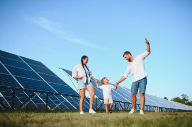 Güneş panelleri yakınında mutlu bir aile. Güneş enerjisi