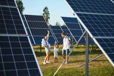 Güneş panelleri yakınında mutlu bir aile. Güneş enerjisi