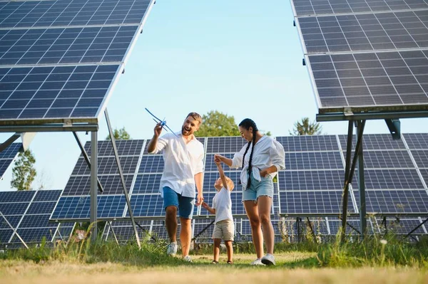 The concept of green energy. Happy family walking and having fun in solar panel field. Green energy