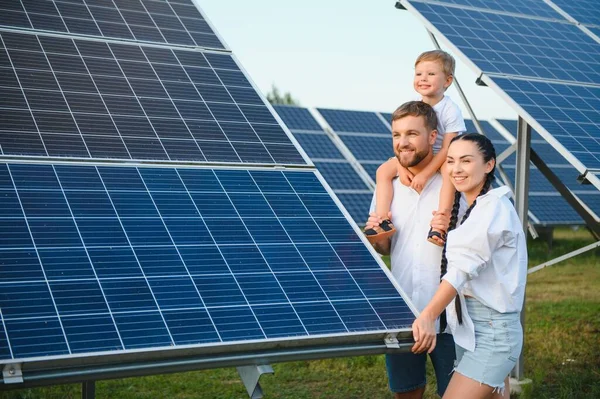 The concept of green energy. Happy family walking and having fun in solar panel field. Green energy