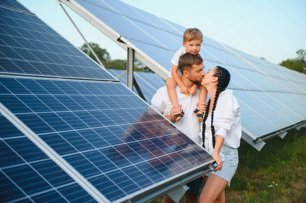 Happy family near solar panels. Alternative energy source.
