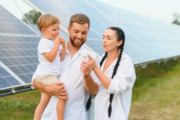 Happy family near solar panels. Alternative energy source.