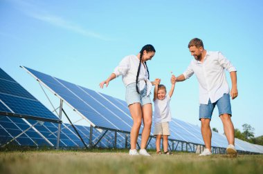 Güneş panelleri yakınında mutlu bir aile. Güneş enerjisi