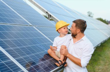 Babası ve küçük oğlu güneş panellerinin yanında.