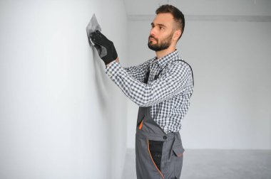 İşçi odada tamirat yapıyor.