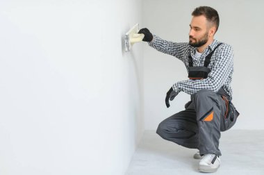 İşçi odada tamirat yapıyor.