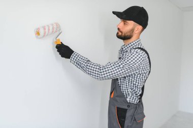 Duvarları boyayan genç bir işçi.