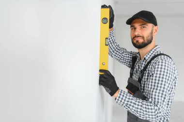 İnşaat işçisi su seviyesi kullanıyor.