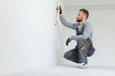 İşçi odada tamirat yapıyor.