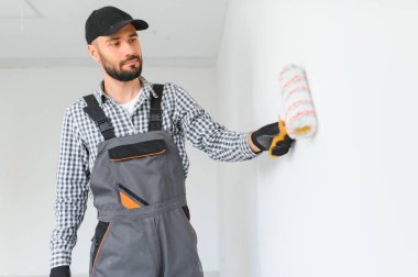 Duvarları boyayan genç bir işçi.