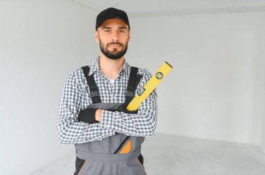 İnşaat işçisi su seviyesi kullanıyor.