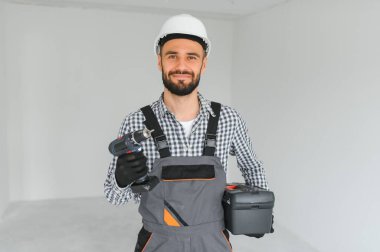 Boş odada yakışıklı bir işçi.