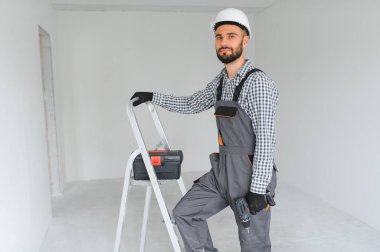 Boş odada yakışıklı bir işçi.