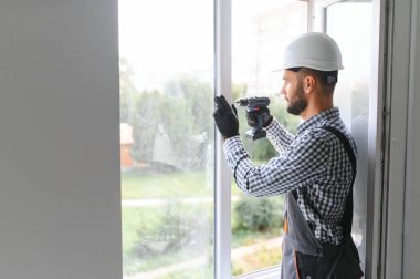 İnşaat işçisi eve pencere kuruyor