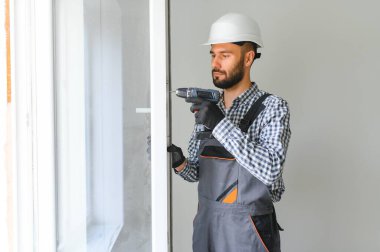İnşaat işçisi eve pencere kuruyor
