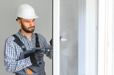 İnşaat işçisi eve pencere kuruyor