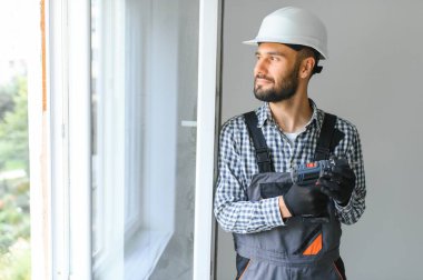 İnşaat işçisi eve pencere kuruyor