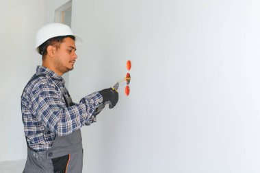 Hintli bir elektrikçi yeni bir binaya priz kuruyor..