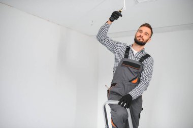 Genç elektrikçi duman dedektörü tavan yükleme