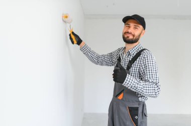 Duvarları boyayan genç bir işçi.