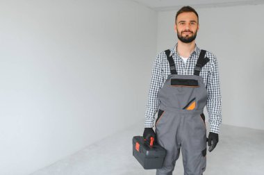 Boş odada yakışıklı bir işçi.