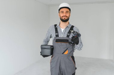 Boş odada yakışıklı bir işçi.