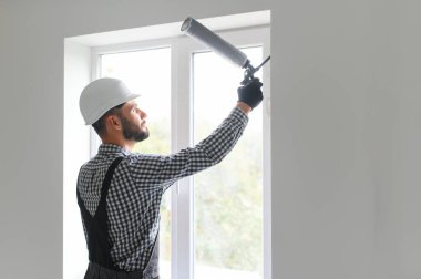 İnşaat işçisi eve pencere kuruyor.