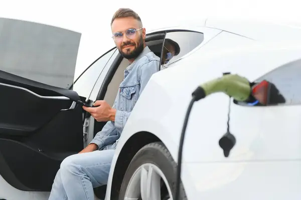 Ein Mann Lädt Ein Elektroauto — Stockfoto