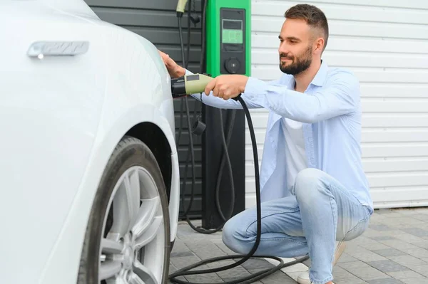 Stylish Man Inserts Plug Electric Car Charging Socket — Stock Photo, Image