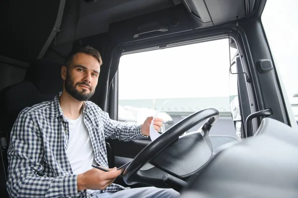 Truck driver sitting in cab.